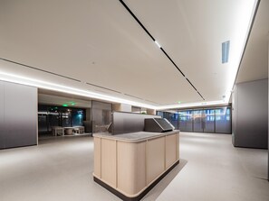 A modern hotel lobby with a central seating area, a glass partition, and a view of the outside. - JI Hotel (xian Jiaotong University Qinglong Templ (Xi'an)