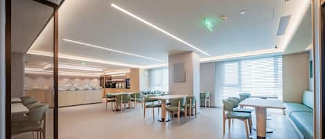 A modern interior with a central dining area, kitchen, and seating space.