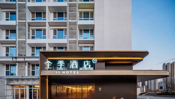 Un hôtel doté d’une façade moderne, d’une grande entrée vitrée et d’une enseigne bien visible.