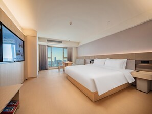A modern hotel room with a large bed, a desk, and a television on the wall. - JI Hotel (xian Jiaotong University Qinglong Templ (Xi'an)