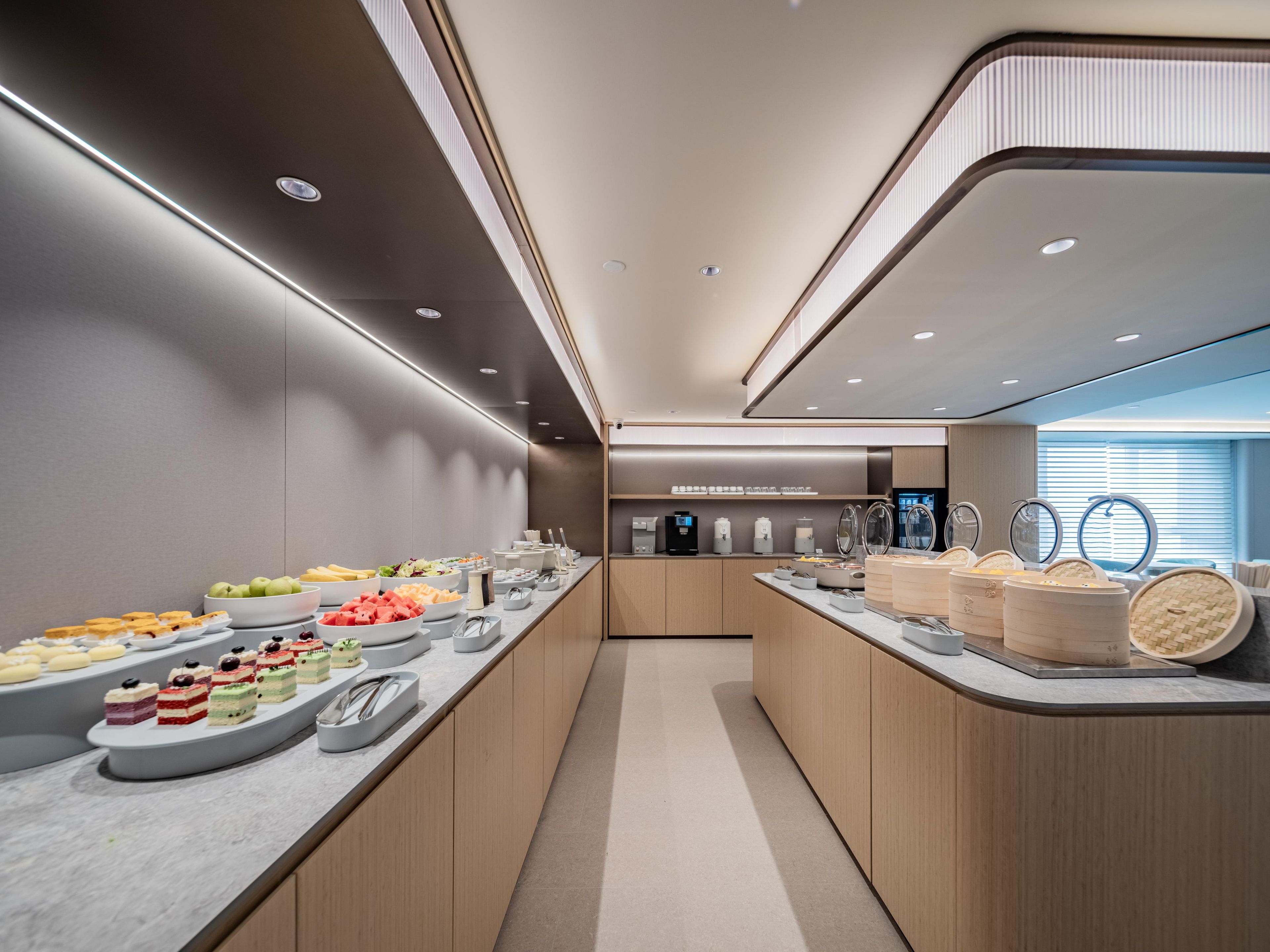 A modern buffet setup with a variety of food items and a self-service beverage station.
