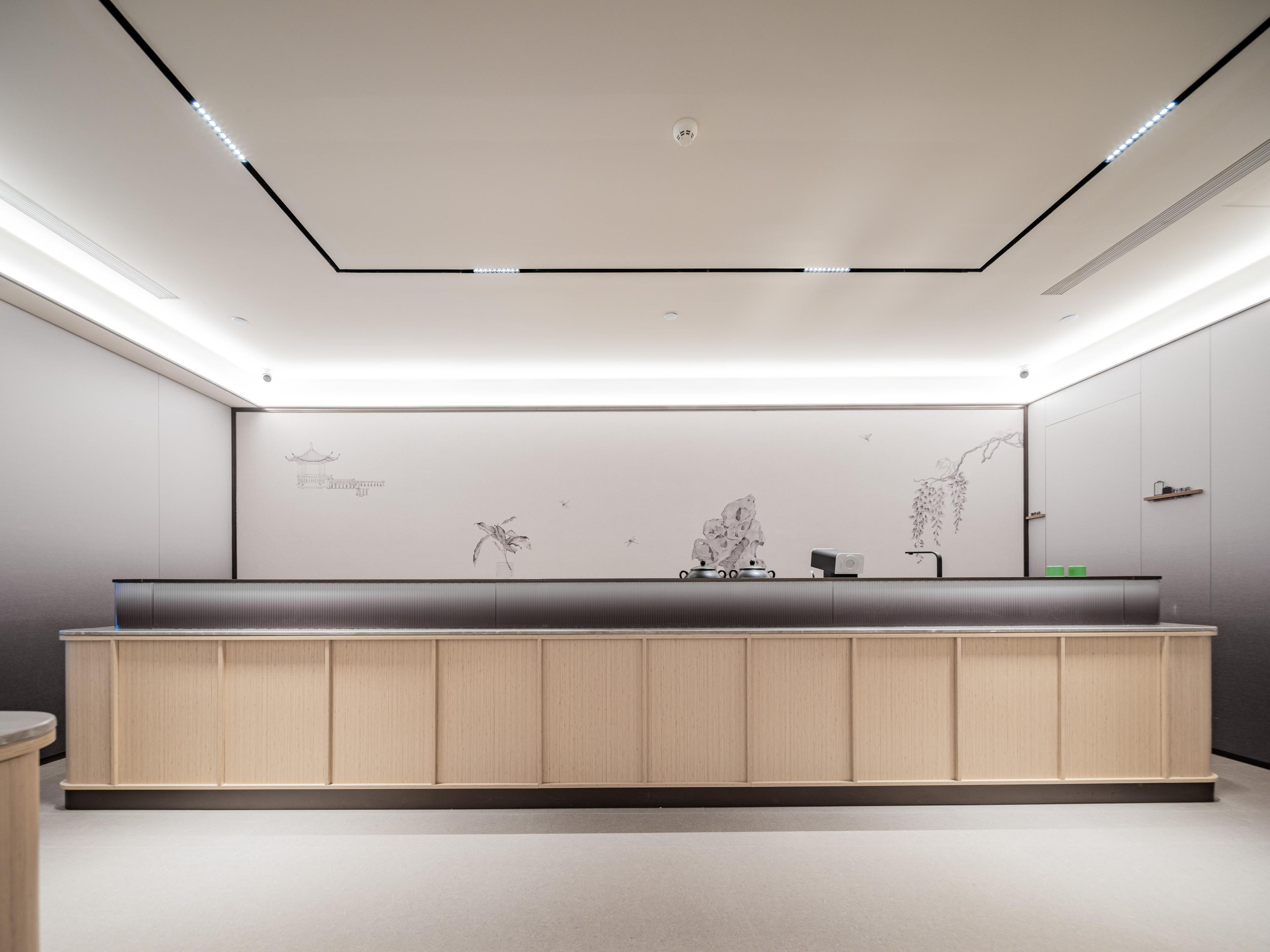 Un baño moderno con tocador de madera, iluminación empotrada y decoración en la pared.
