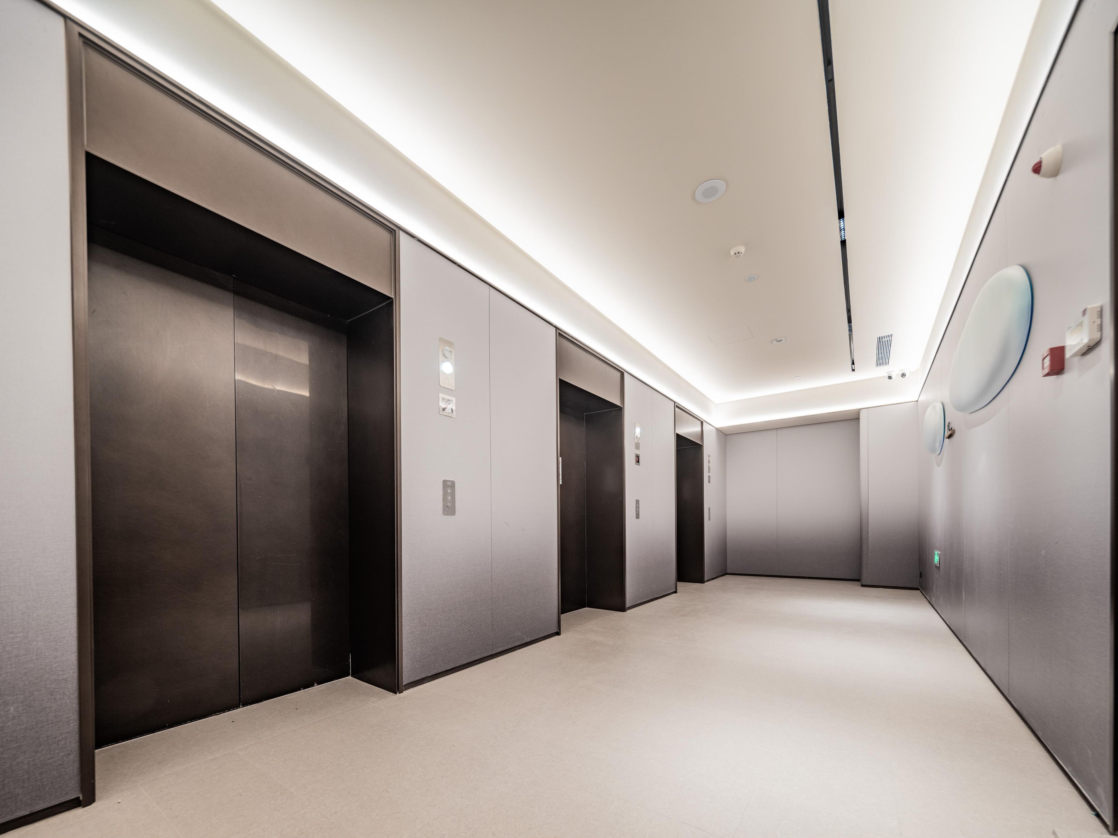 A modern elevator area with metallic elevator doors and a light-colored floor.