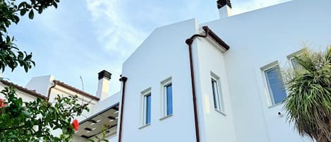A modern building with multiple windows and a white facade.