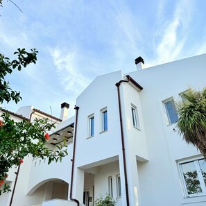 A modern building with multiple windows and a white facade.
