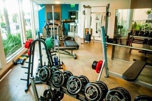 Una palestra con attrezzi per l'allenamento con i pesi, tapis roulant e macchinari per esercizi.