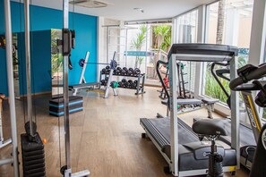 A gym with exercise equipment, a treadmill, and a rack of dumbbells. - Perfect for Spa-Goers! Elegant Room in the Heart of Foz do Iguaçu (Paraná)