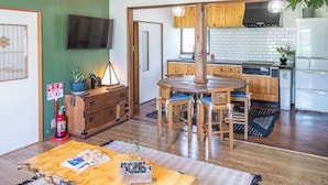 Une cuisine moderne avec des meubles en bois, un four encastré et un coin repas comprenant une table et des chaises en bois.
