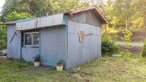Un petit bâtiment d’un seul étage, doté d’un toit en tôle ondulée et d’une porte à enroulement fermée.