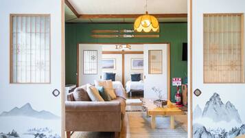 A traditional Japanese-style room with tatami flooring, a low wooden ceiling, and sliding doors.