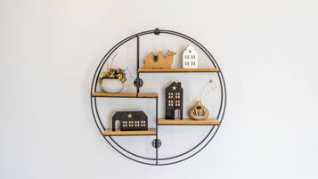 Uno scaffale circolare fissato al muro, decorato con diversi oggetti.