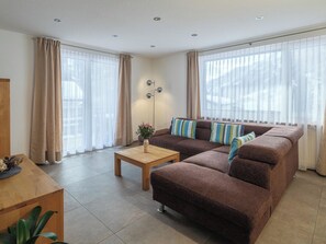 Ein Wohnzimmer mit einem braunen Sofa, einem Holztisch und einer Stehlampe.