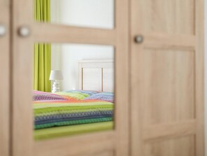 Habitació amb un llit, una làmpada i una cortina verda.