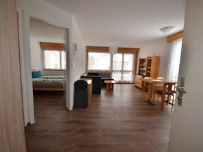 A spacious living area with a sofa, a dining table, and a kitchenette. - Fortuna 302 # 3-bed apartment, Dusche, WC 3-Bettwohnung, Dusche, WC by Interhome (Leukerbad)