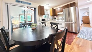 A modern kitchen with a dining table, chairs, and a refrigerator. - 2Bed 1Bath- ½ Mile walk to Mayflower, central A/C, CLEAN w/ washer/dryer (Dennis)