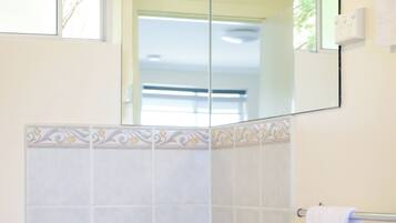 A bathroom with a white sink, a mirror, and a towel rack.