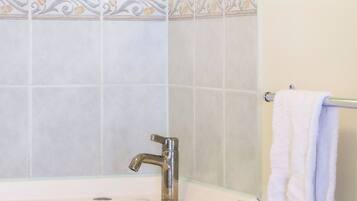 Een douche, handdoeken, zeep, shampoo