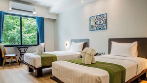 A hotel room with two beds, a desk, and a chair. - Nouriva Place Bangkok (Bangkok)