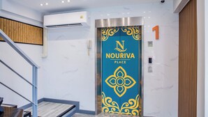 A modern elevator with a decorative blue and gold design, a visible phone, and a security camera above. - Nouriva Place Bangkok (Bangkok)