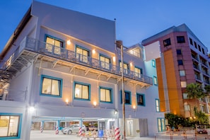 Hotel com vários andares, varandas, garagem e vista para a rua.
