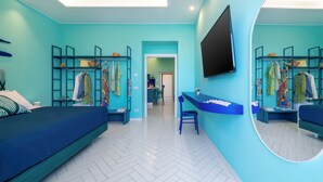 A modern bedroom with a bed, a desk, and a mirror.