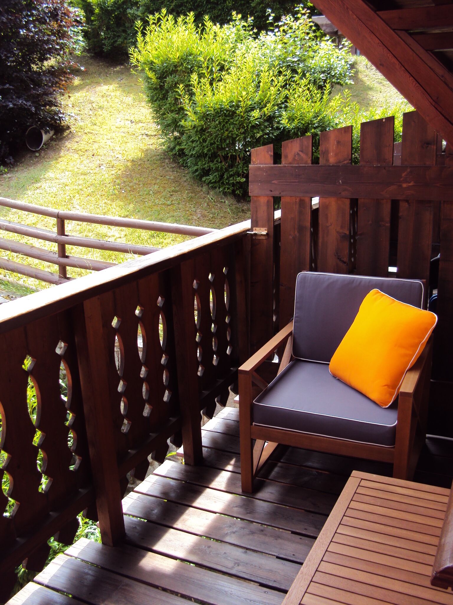 A wooden deck with a chair and a table.