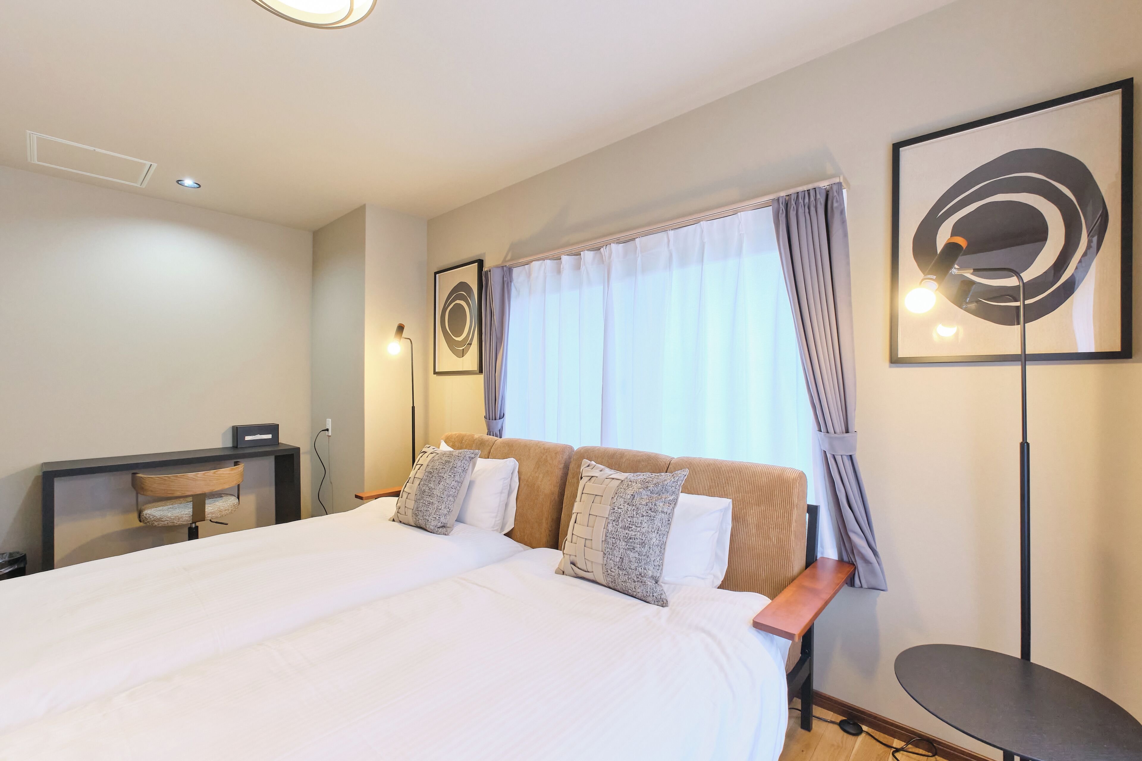 Ein Hotelzimmer mit einem großen Bett, einem Schreibtisch, einem Stuhl und einem kleinen Tisch.