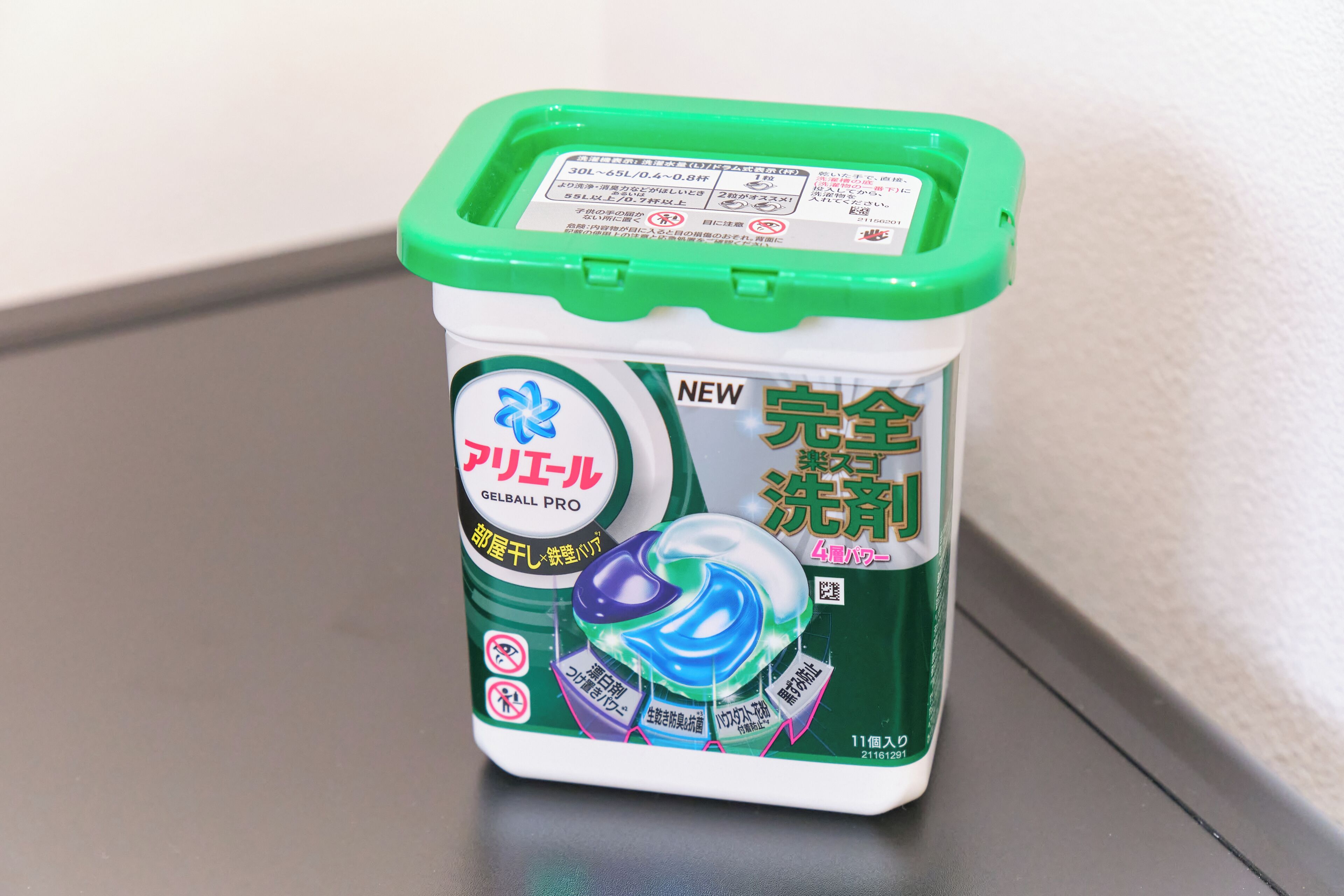 A container of gel with a green lid and label, placed on a flat surface.