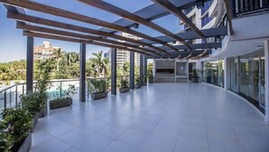 A spacious outdoor area with a pool, potted plants, and a view of surrounding buildings. - Corporate Stays The Tower (Asunción)