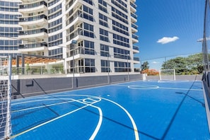 A multi-story building with a basketball court in the foreground. - Corporate Stays The Tower (Asunción)