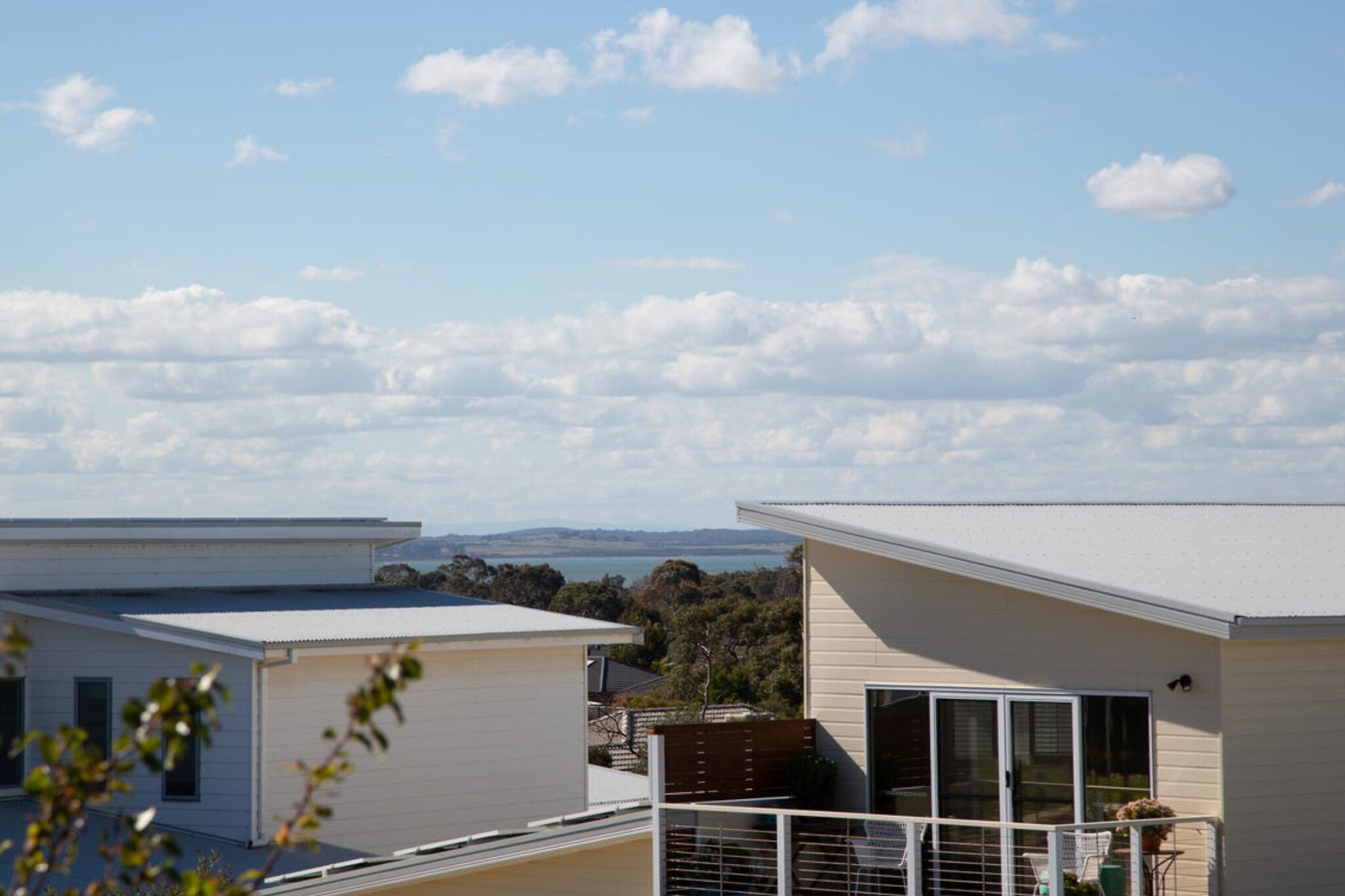 A residential area with two houses, one with a balcony and large windows, and another with a garage.