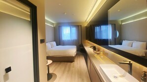 A hotel room with a bed, a large mirror, a bathroom with a sink, and a window with curtains. - Crystal Orange Hangzhou Zhejiang Univ. (Hangzhou)