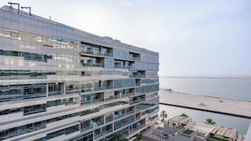 Ein modernes Mehrstöckiges Hotel mit Balkonen, einem Poolbereich und Blick aufs Meer.