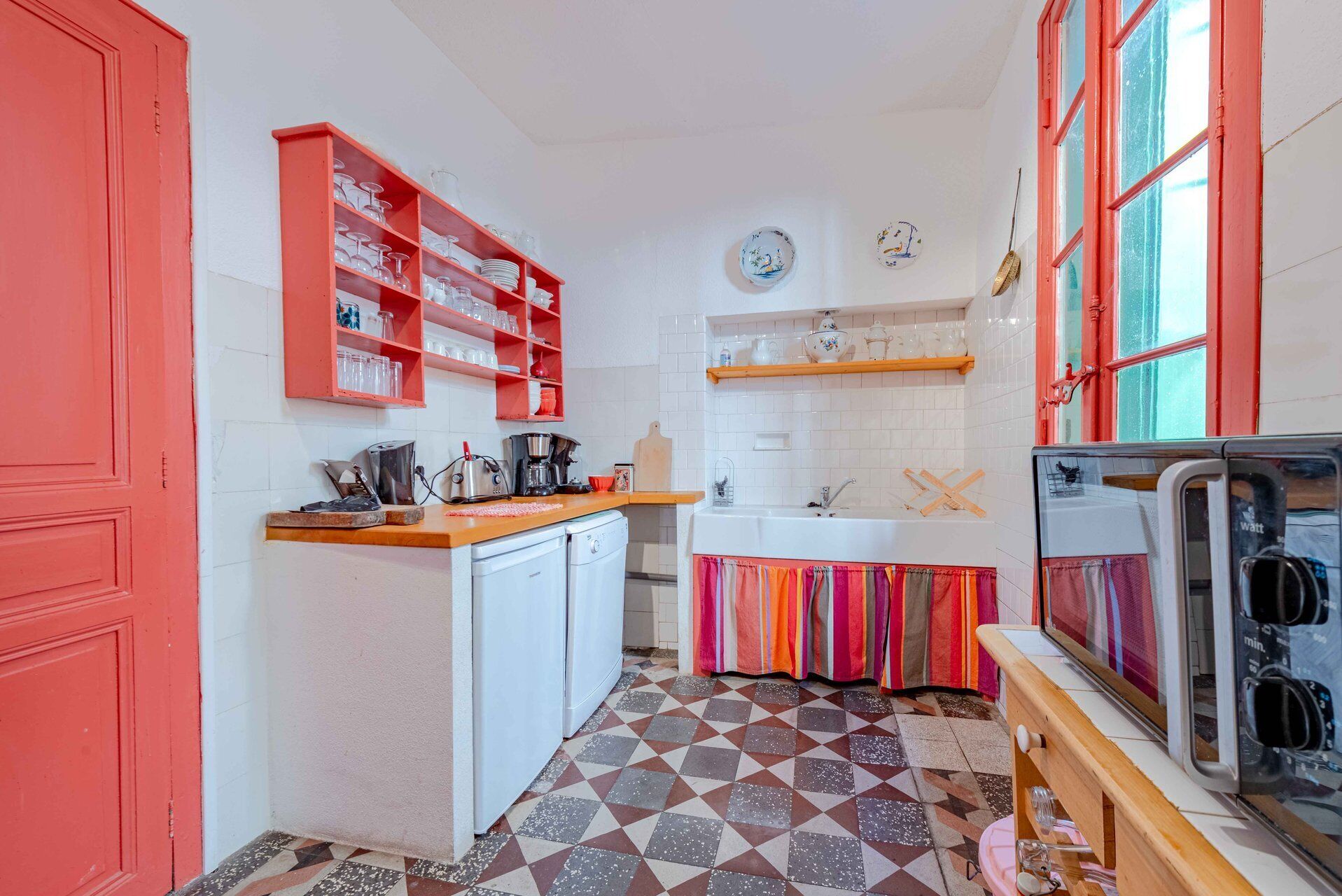 A compact kitchen with a refrigerator, a sink, and a microwave.