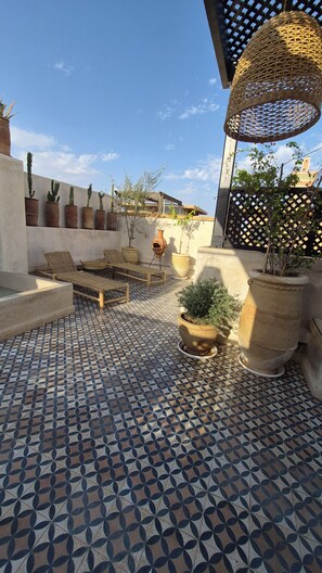 A courtyard with patterned tiles, potted plants, and outdoor furniture. - Welcome to Dar Ineza, 7 km from downtown. Private pool + rooftop with a pool (Marrakech)