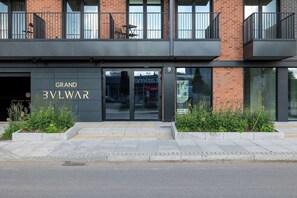 Ein modernes Gebäude mit einem Schild, auf dem 'GRAND 3VLWAR' steht, und einem gut sichtbaren Eingang.