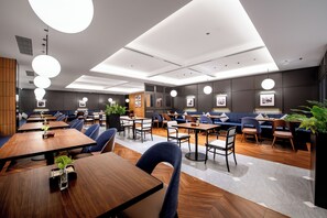 A modern restaurant with multiple seating areas, including tables and booths, and a central bar area. - IntercityHotel Hangzhou Yuhang Xianlin (Hangzhou)
