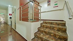 A hotel corridor with a staircase featuring stone steps and a metal handrail. - RS Hotel (Johor Bahru)
