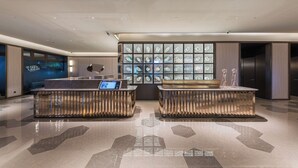A modern lobby with a reception desk, seating area, and a large window display.