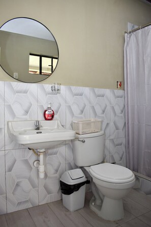 A bathroom with a sink, toilet, and a mirror. - Vrbo Property (Huaraz)