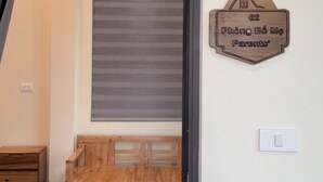 A room with a wooden bench, a wall-mounted sign, and a closed shutter.