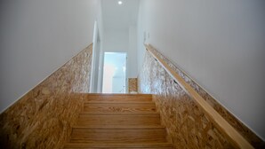 Un escalier en bois offrant une vue sur une pièce située à l’étage supérieur.