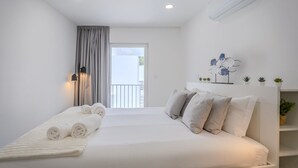 Une chambre d’hôtel moderne, équipée d’un lit, d’une lampe de chevet, d’une sculpture métallique décorative et offrant une vue sur l’extérieur.