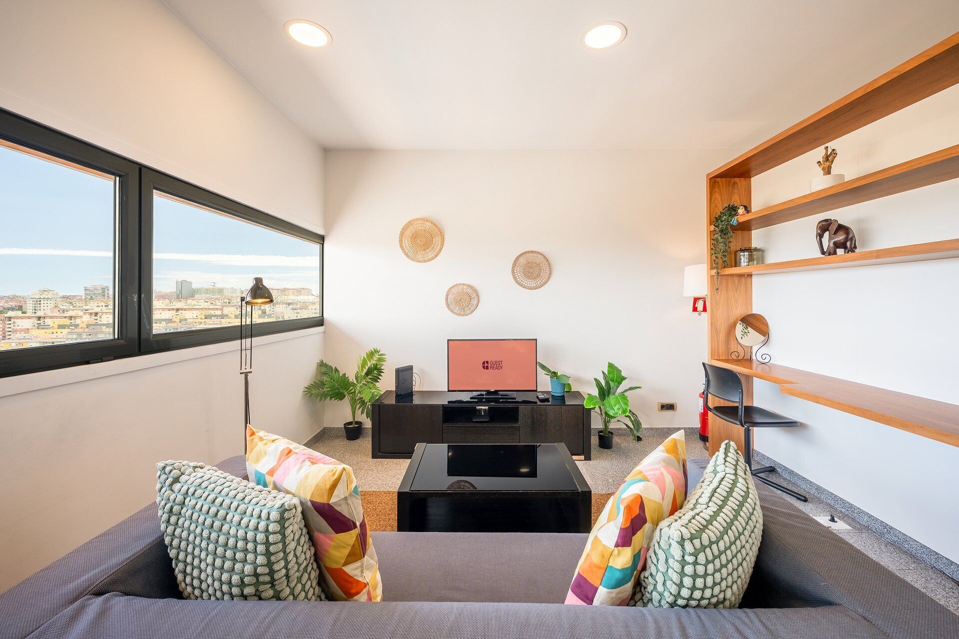 Un salon moderne avec un canapé, un téléviseur et des objets de décoration.