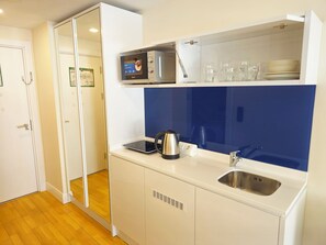 A compact kitchen with a built-in oven, a kettle, a sink, and a microwave. - 24home.batumi-3718 on the Black Sea coast (Batumi)