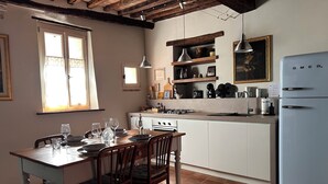 Eine Küche mit Esstisch, Stühlen, einem Kühlschrank und verschiedenen Küchenutensilien.