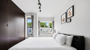 Habitación de hotel con una cama grande, un armario de madera oscura y vistas al exterior.