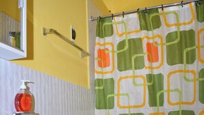 A bathroom with a toilet, a sink, and a shower curtain with a geometric pattern.