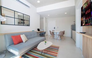 Ein modernes Wohnzimmer mit einer Couch, einem Couchtisch und einem Essbereich mit Stühlen.