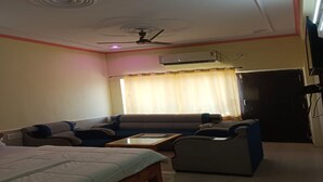 A room with a bed, sofa, armchair, and a small table. - Hotel Karni Fort (Kuchaman)